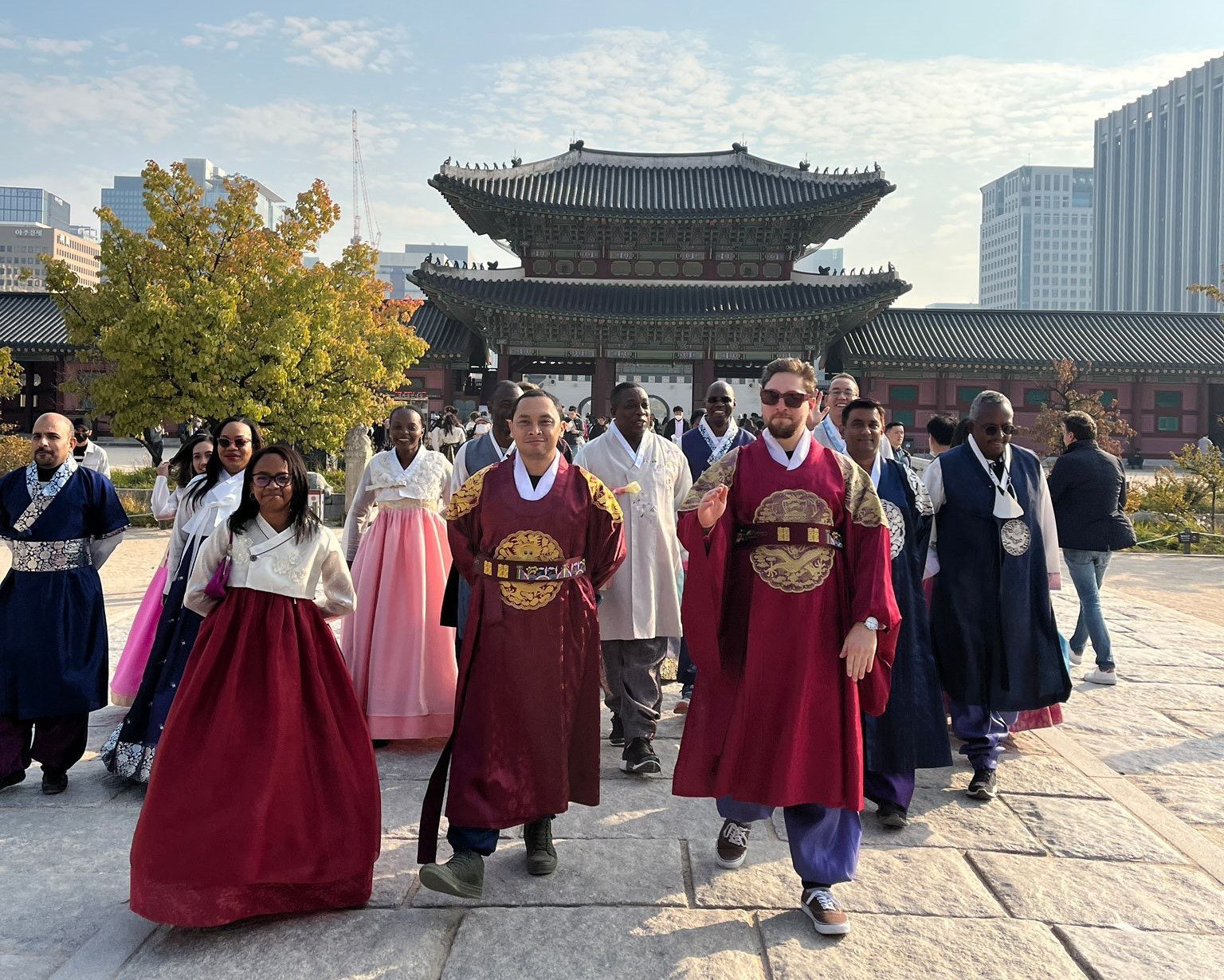 Guide and guests in hanbok walking toward the gate of Gyeongbokgung Palace